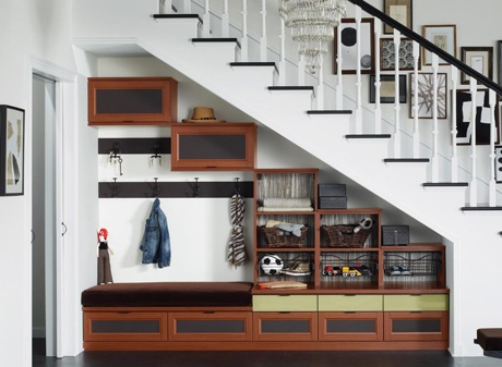 Storage underneath floating staircase with drawers, compartments, and hooks